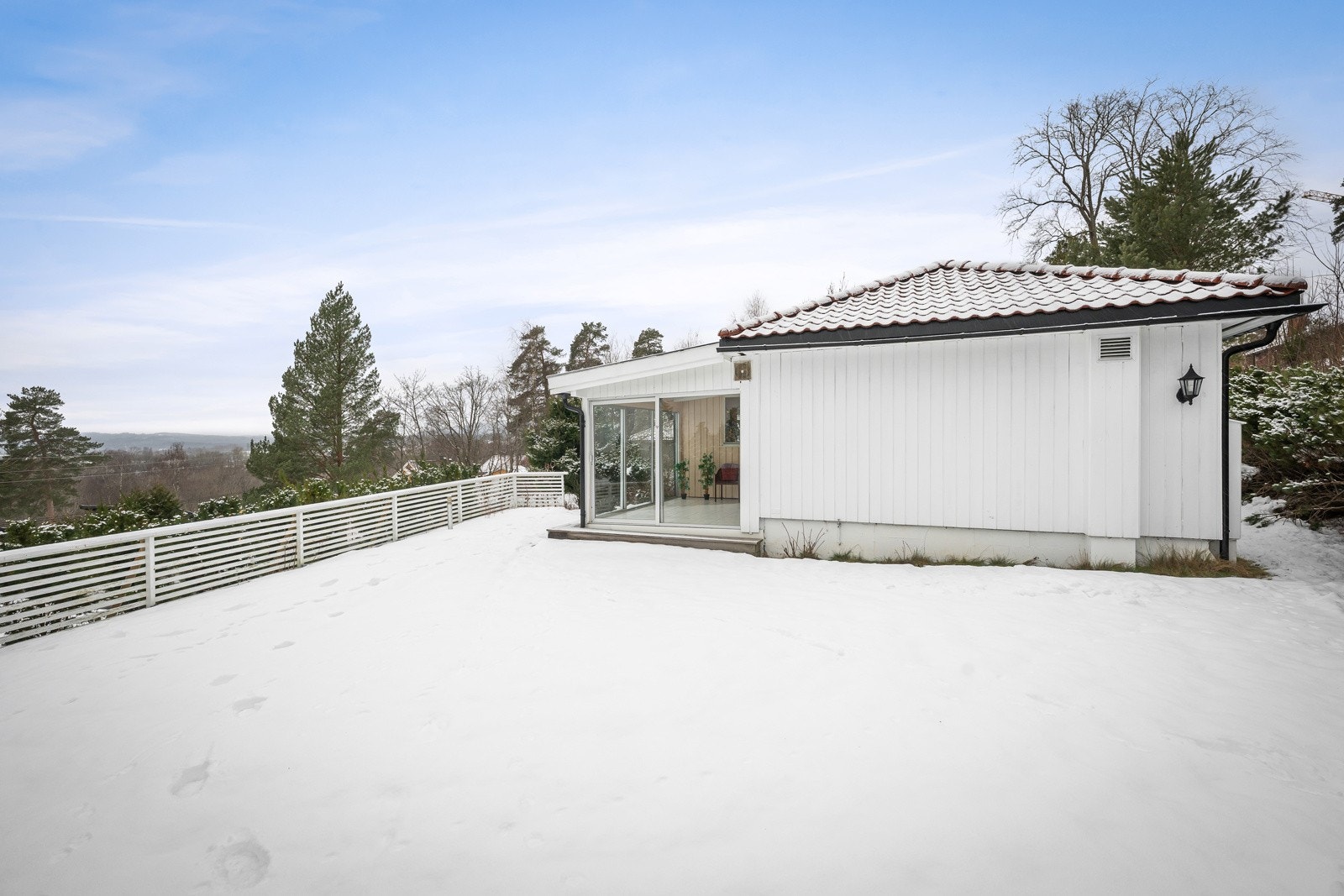 Tomten er omkranset av både plenarealer, naturtomt, busker og beplantning, og gir en fin kombinasjon av skjerming, lekearealer og soner med sol. Galleribilde