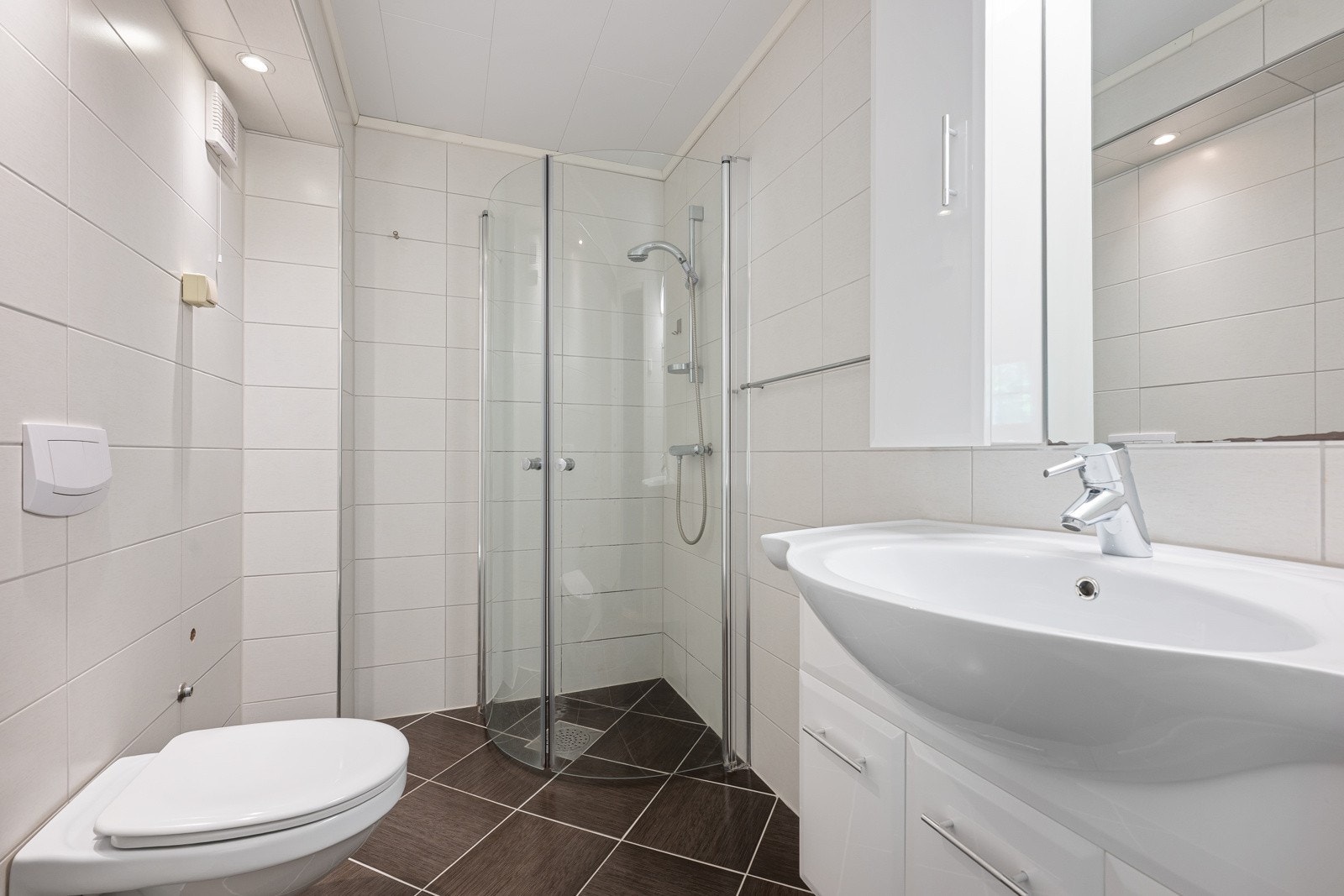 Badet, som ligger i en del som leies ut, er innredet med dusjhjørne, toalett, servant med underskap og overskap. Galleribilde