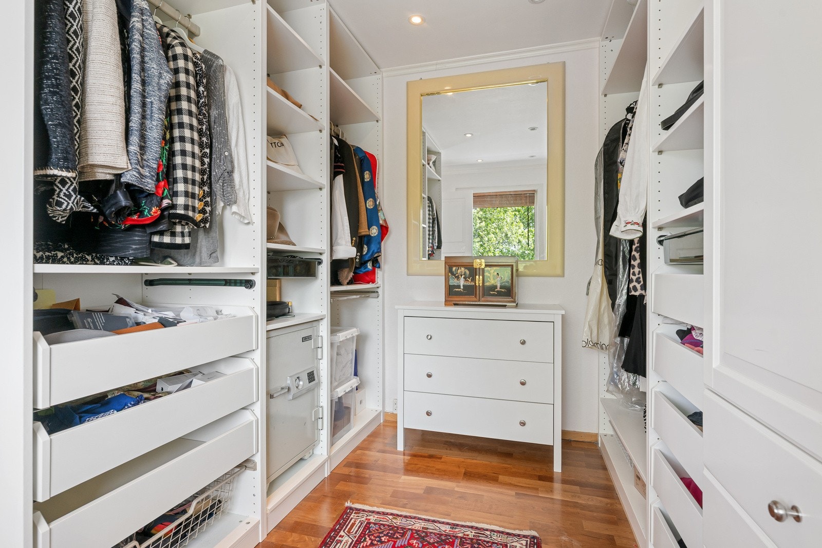 Herfra er det adkomst til et praktisk walk-in-closet, innredet med garderobeskap på begge sider som gir rikelig skapplass. Galleribilde