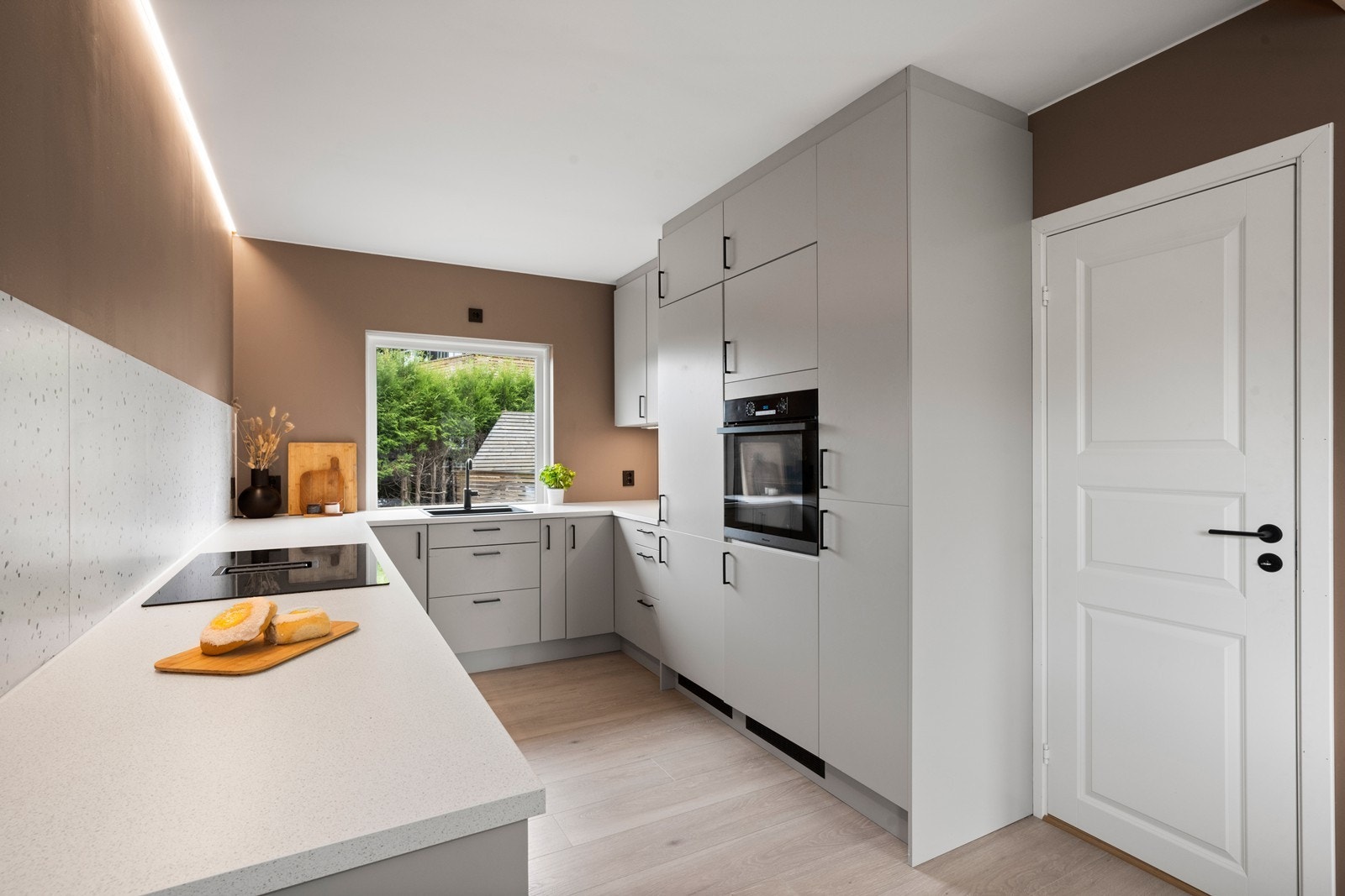 Lekkert kjøkken fra 2023 med oppvaskmaskin, kjøleskap, induksjonstopp, stekeovn, vannstoppesystem samt komfyrvakt Galleribilde