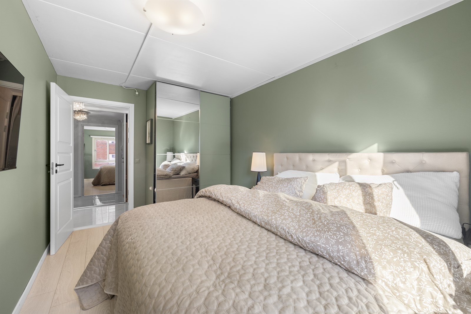 Store vindusflater gir rikelig med naturlig lys og bidrar til en lun og behagelig atmosfære på soverommet. Galleribilde