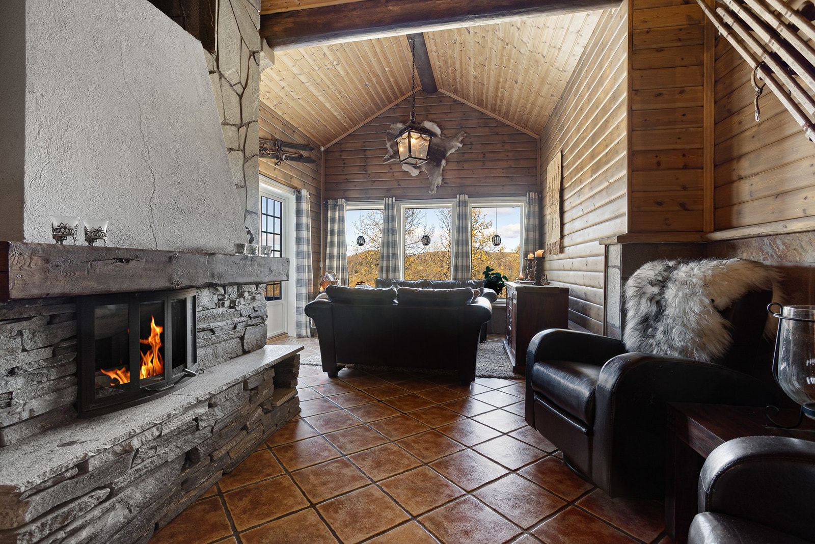 Nydelig stue med høyt under taket og store vindusflater som bringer utsikten inn i rommet Galleribilde