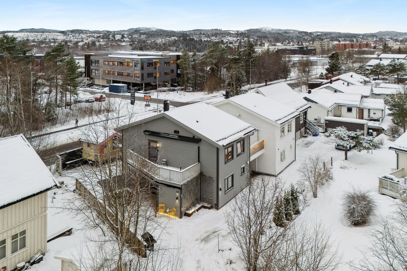 Steinlagt gårdsplass i fiskebeinsmønster med biloppstillingsplass. Lader for el-bil. Galleribilde