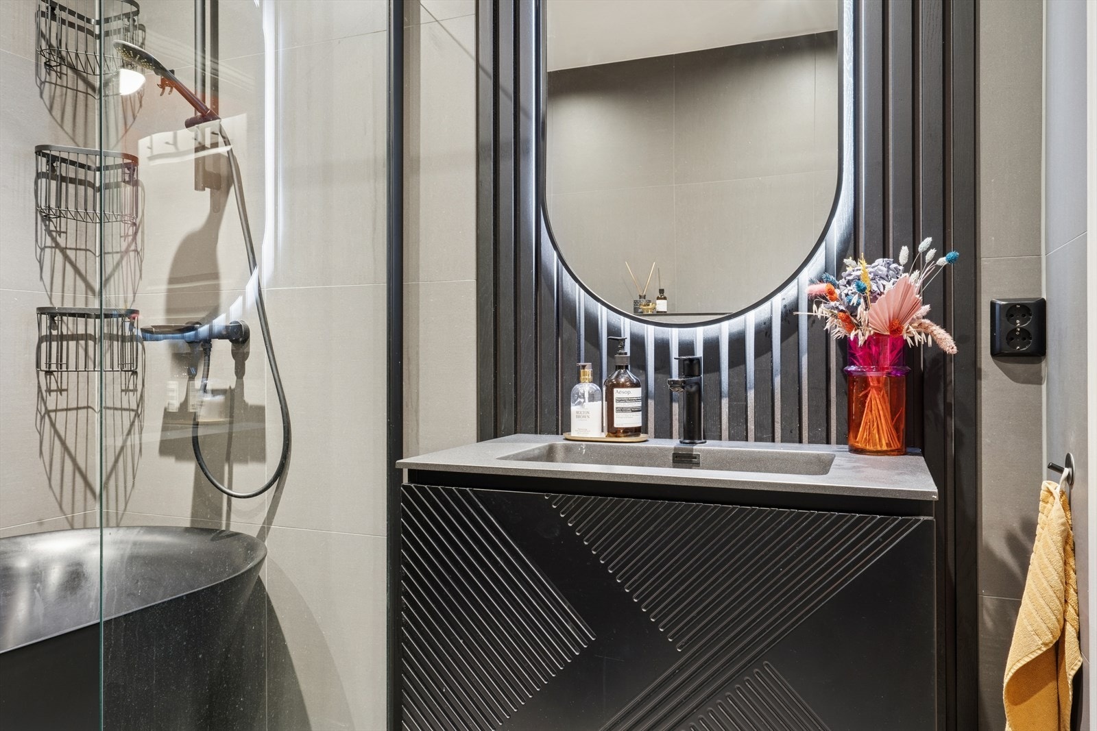 Baderom i 2. etasje med veggmontert toalett, servant med skuffer og speil, samt badekar med dusjnisje. Gulvvarme. Galleribilde