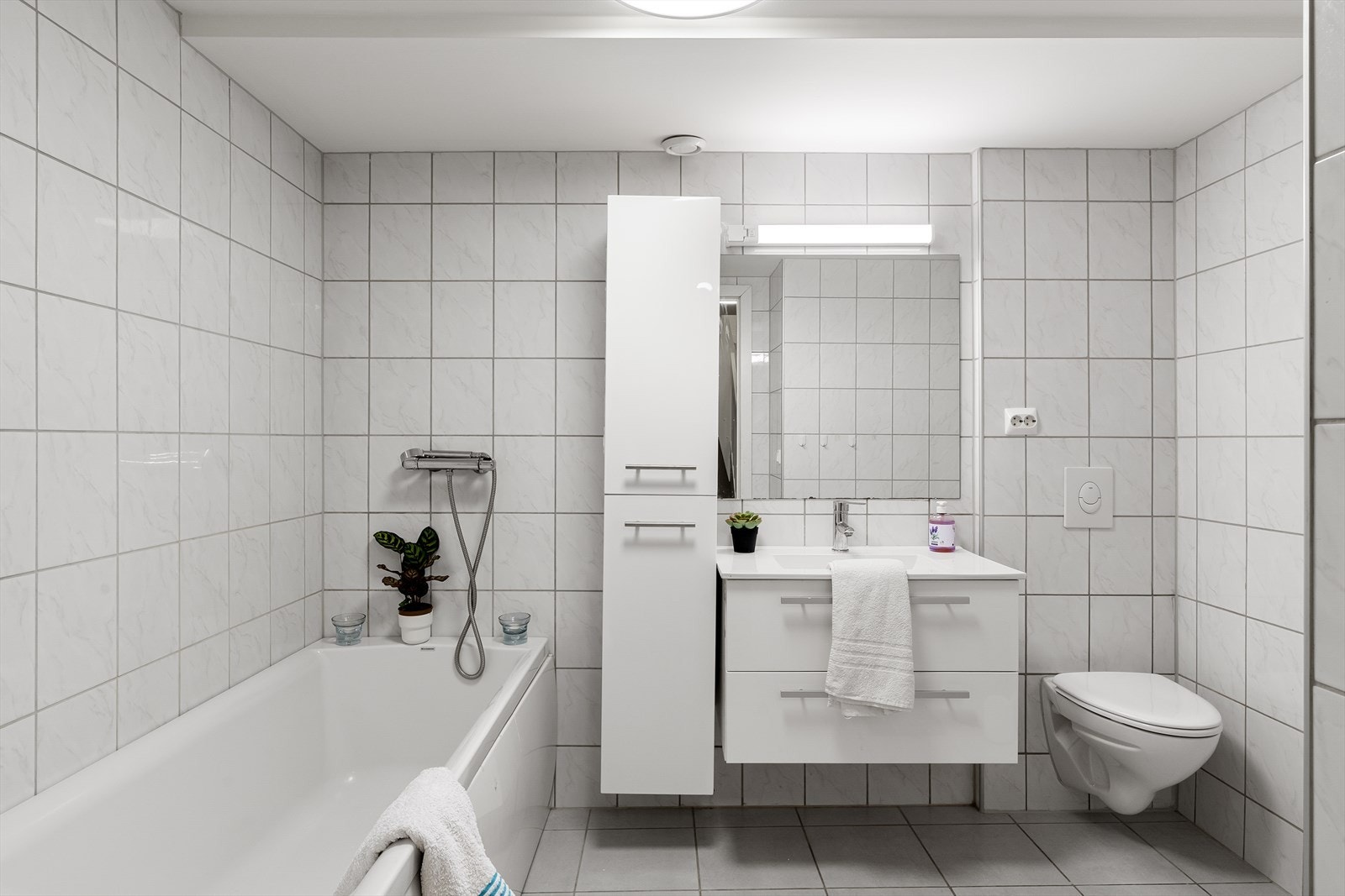 Helfliset kombinert bad og vaskerom med gulvvarme Galleribilde