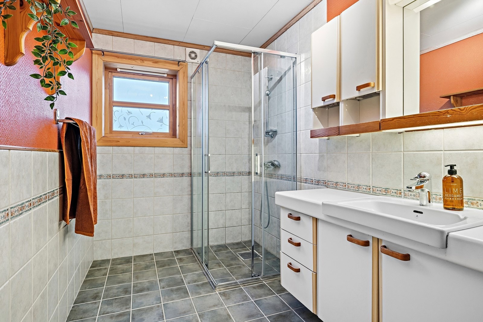 Rommet har flislagt gulv og vegger med flis og malt strie. Galleribilde