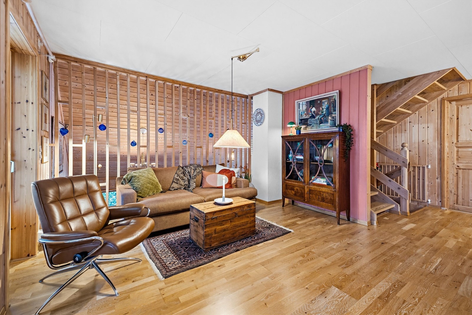 En dekorativ spilevegg skiller stuen i 1. etasje fra stuen i halvetasjen under. Galleribilde