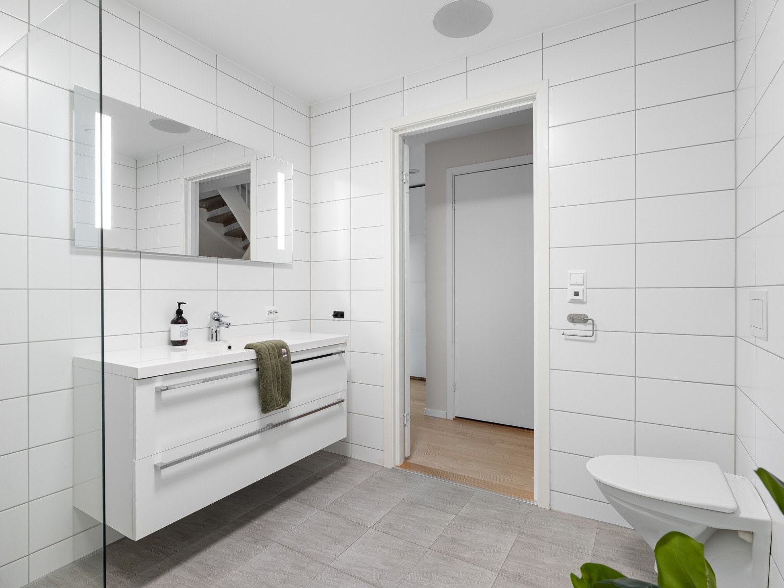 Innredningen består av en praktisk baderomsinnredning med nedfelt servant, veggmontert toalett og dusjhjørne med nedsenket gulv. Det er også opplegg for badekar. Galleribilde