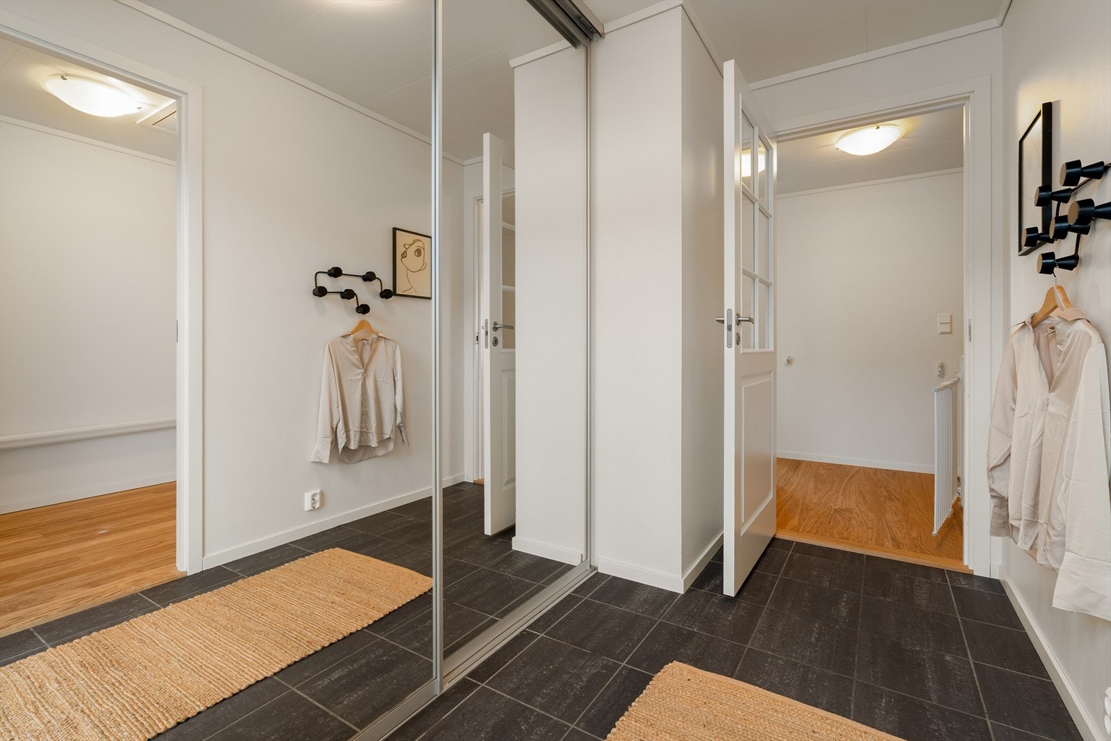I boligen ønskes man velkommen av en lys og praktisk entré, hvor en romslig skyvedørsgarderobe gir god plass til yttertøy og sko - en gjennomtenkt løsning for hverdagslogistikken. Galleribilde