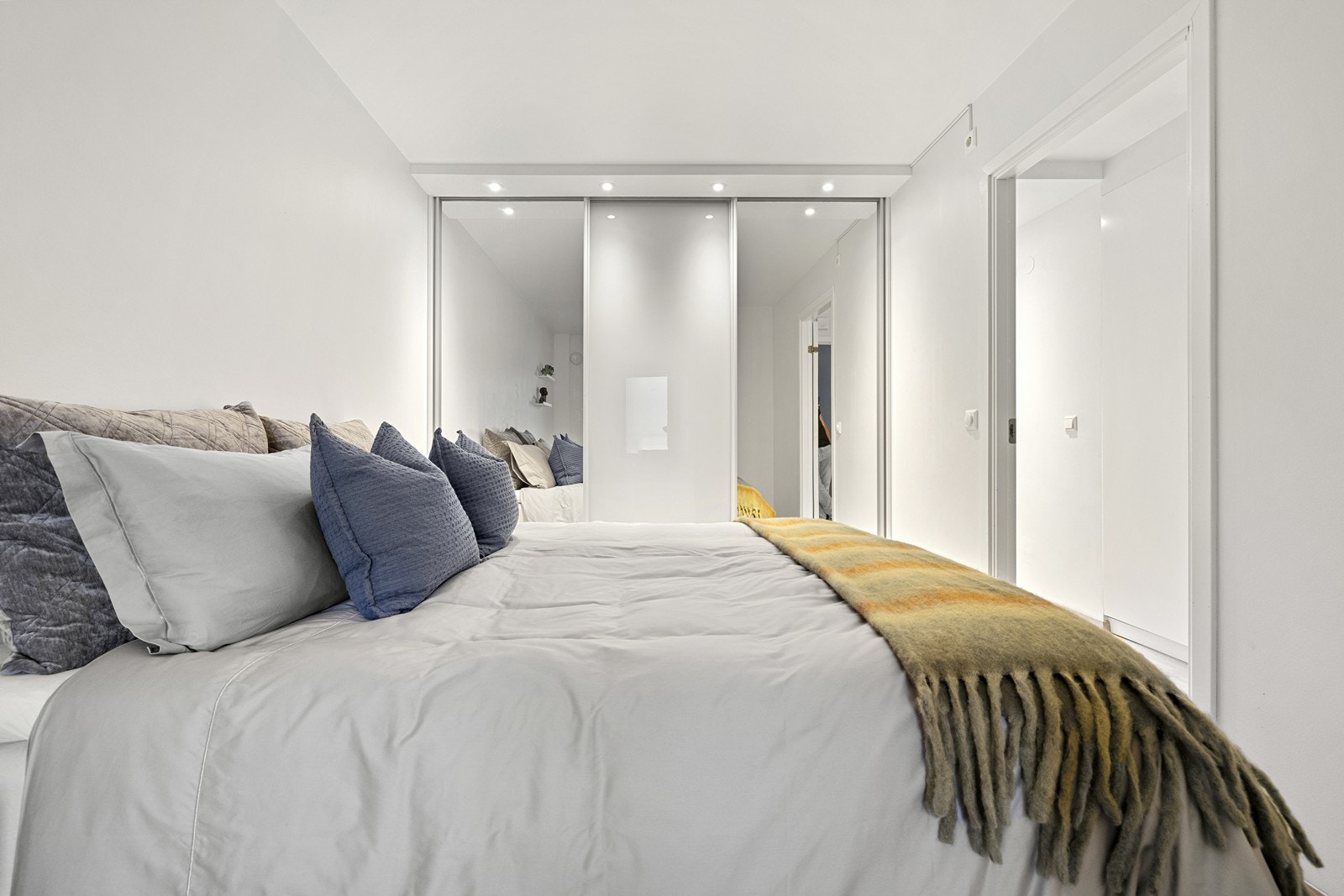 En stor skyvedørsgarderobe med speilfronter gir rikelig med oppbevaringsplass. Galleribilde