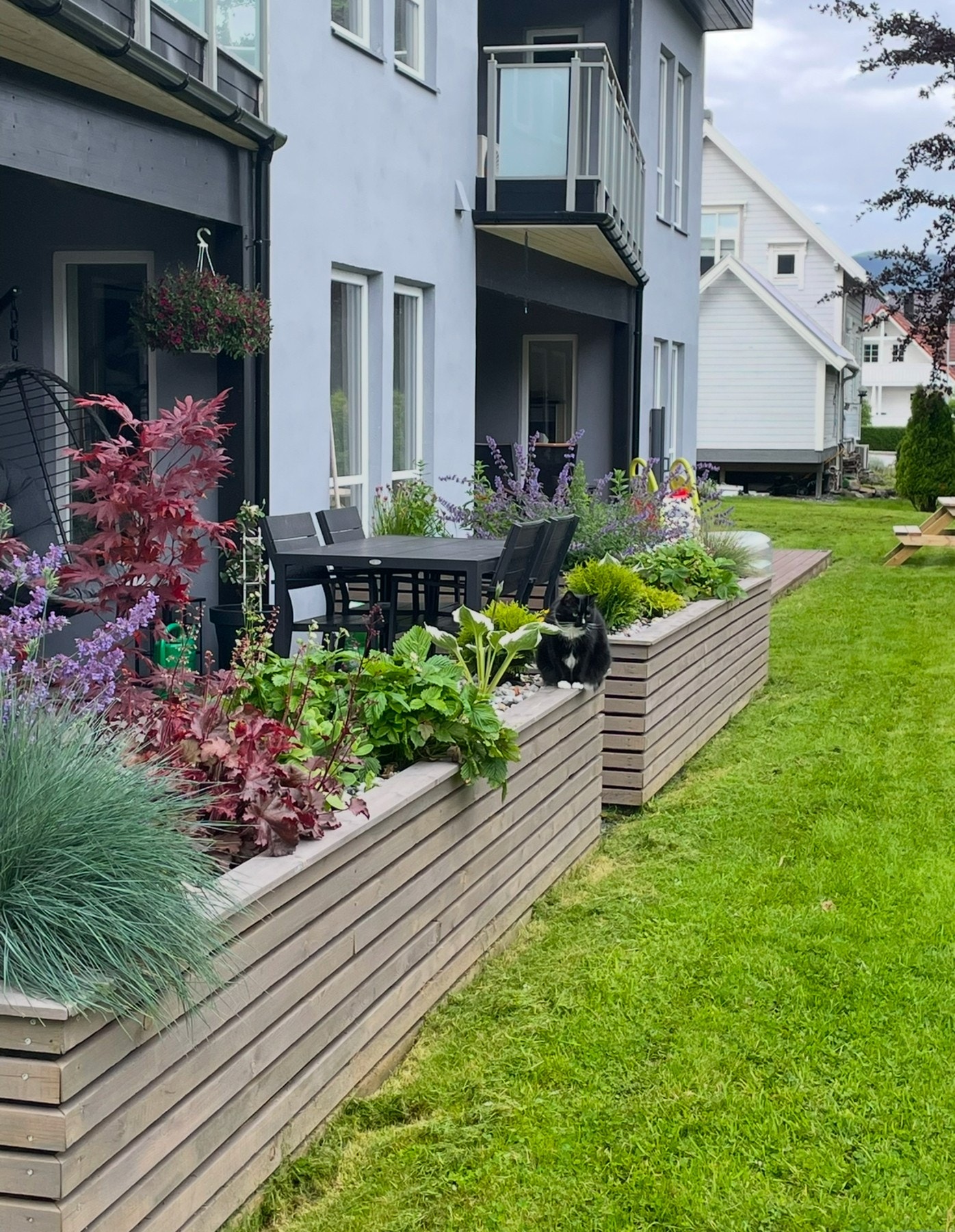 Terrassen blir skjermet med beplanting når det er vår- og sommer. Galleribilde