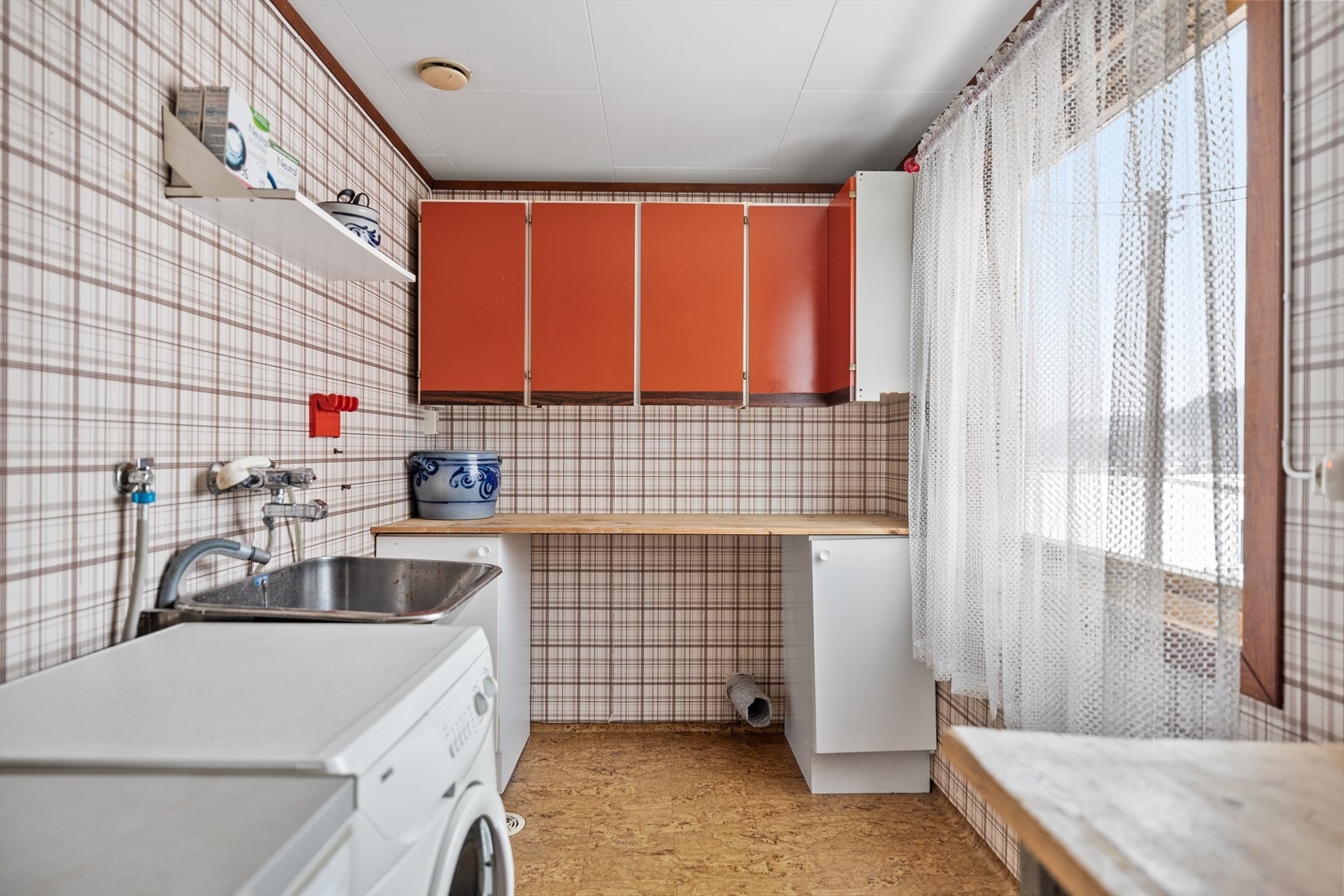 Vaskerom med opplegg for vaskemaskin, dyp stålkum og innredning. Galleribilde