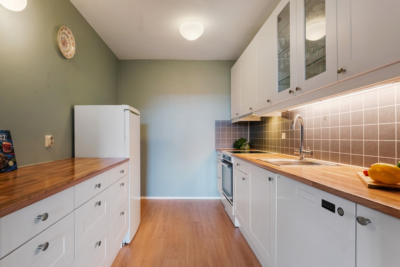 Flott kjøkkeninnredning med hvite fronter og laminert benkeplate Galleribilde