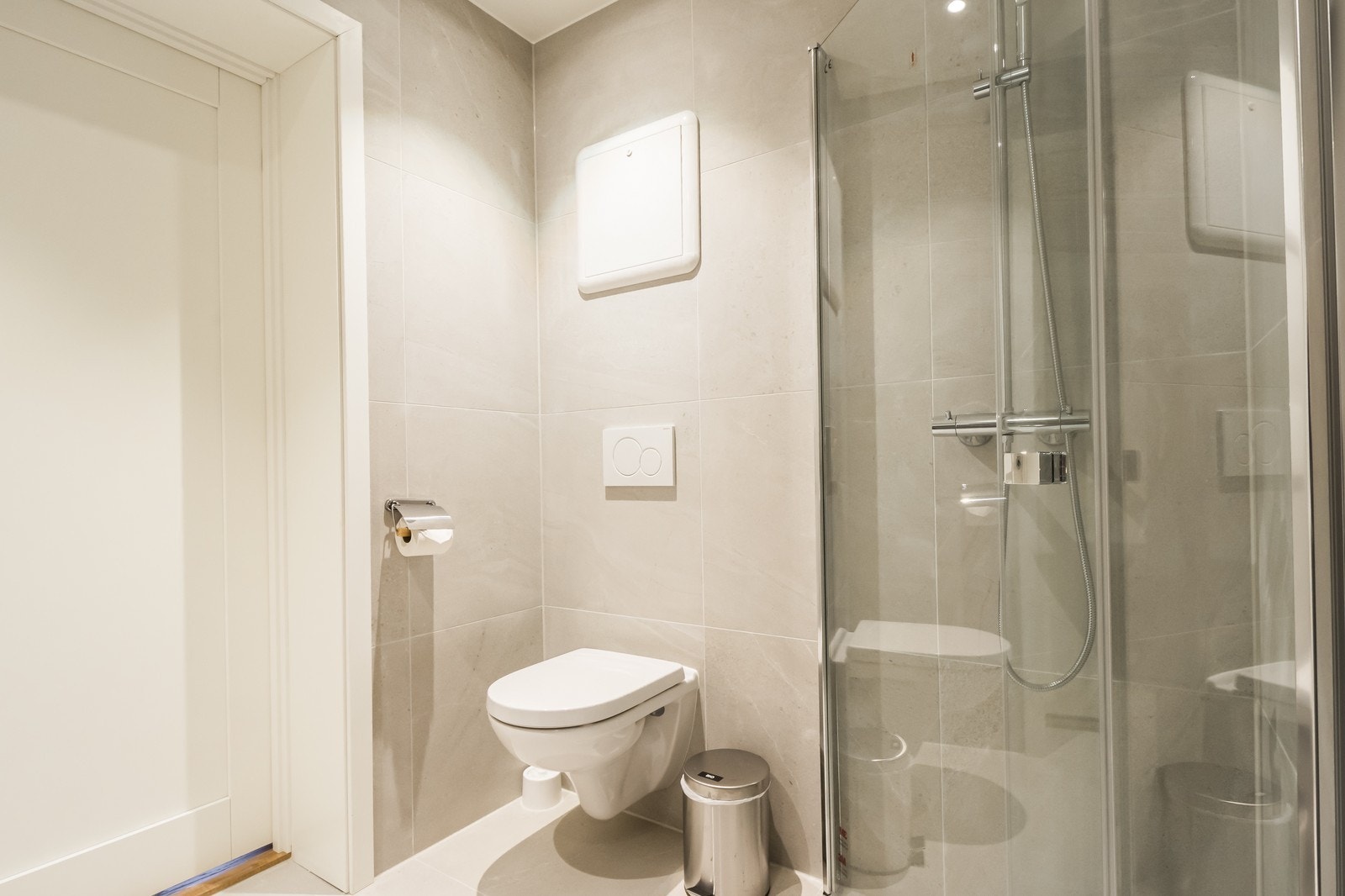 Lyst, flislagt bad med varmekabler og opplegg til vaskemaskin. Galleribilde