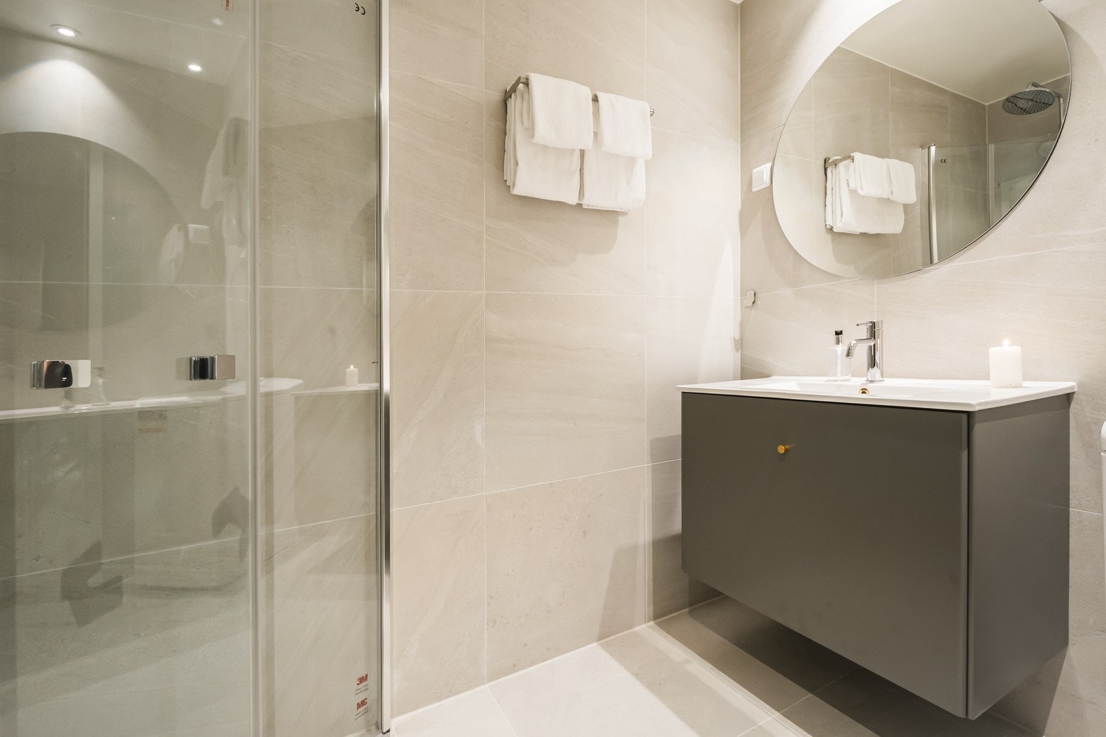 Lyst, flislagt bad med varmekabler og opplegg til vaskemaskin. Galleribilde