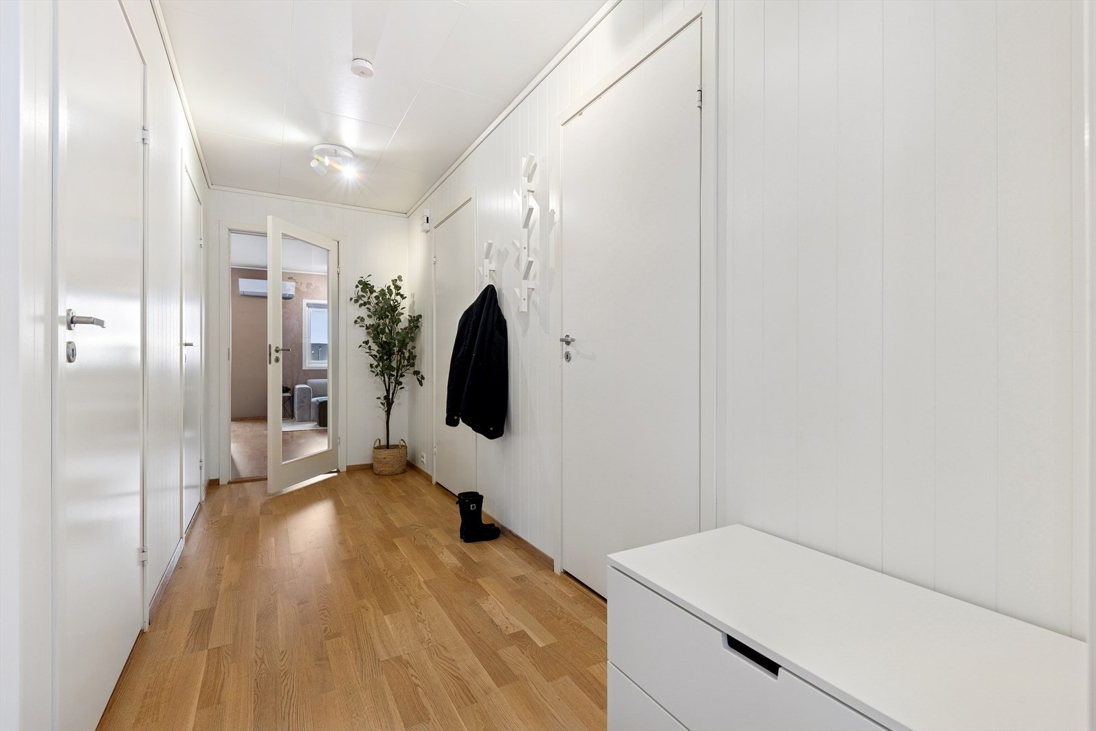 Man ønskes velkommen inn i en romslig og lys gang hvor man har god plass til å henge fra seg yttertøy og sko. Galleribilde
