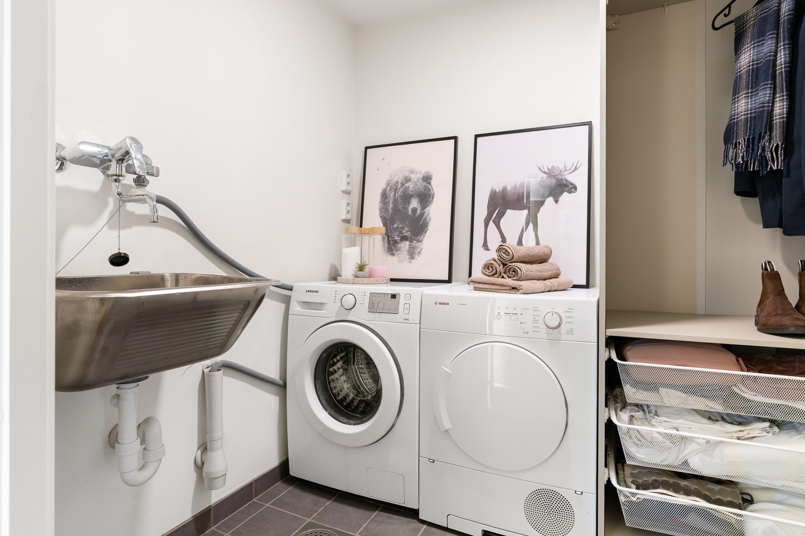 Et praktisk separat vaskerom som bidrar til en ryddig og funksjonell hverdag. Flislagt gulv med sluk, opplegg for vaskemaskin/tørketrommel og utslagsvask. Dobbeltstikk klart dersom man ønsker å ha tørketrommel over eller vedsiden av vaskemaskinen. Galleribilde