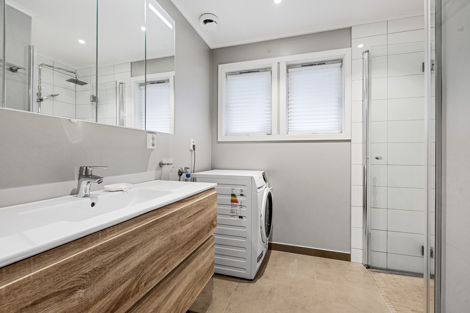 Bad fra 2020 med fliser på gulv med varmekabler og malte plater på vegger. Dusjnisje med fliser og glassdør Galleribilde