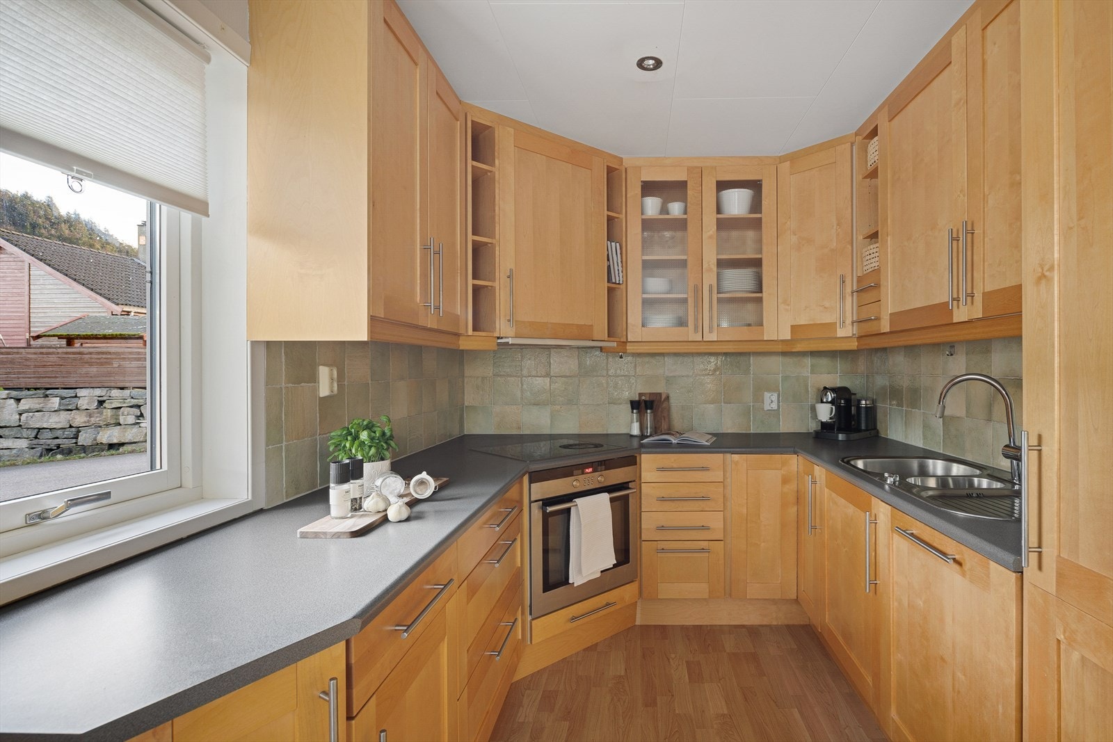 Innholdsrikt kjøkken med mye skap- og benkeplass. Galleribilde