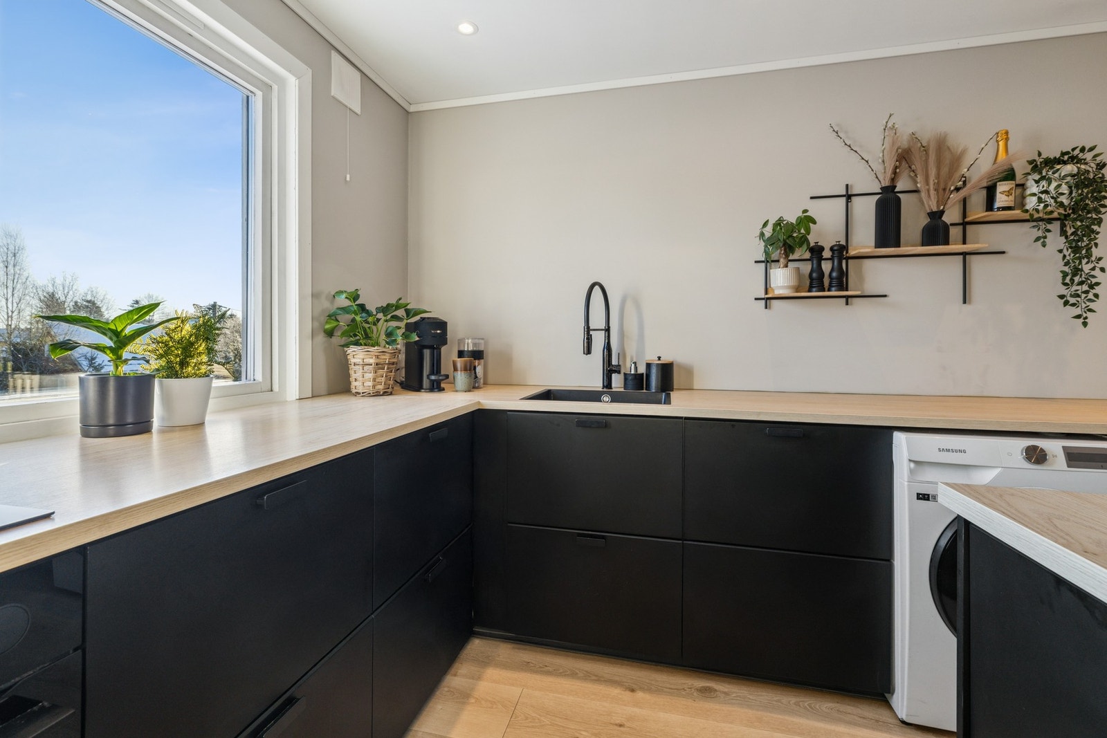 Kjøkken med åpen løsning mot stue. Kjøkkeninnredning med slette fronter fra 2021/2022. Benkeplater av laminat. Nedfelt oppvaskkum med ettgreps armatur. Stikkontakter over benkeplate. Galleribilde