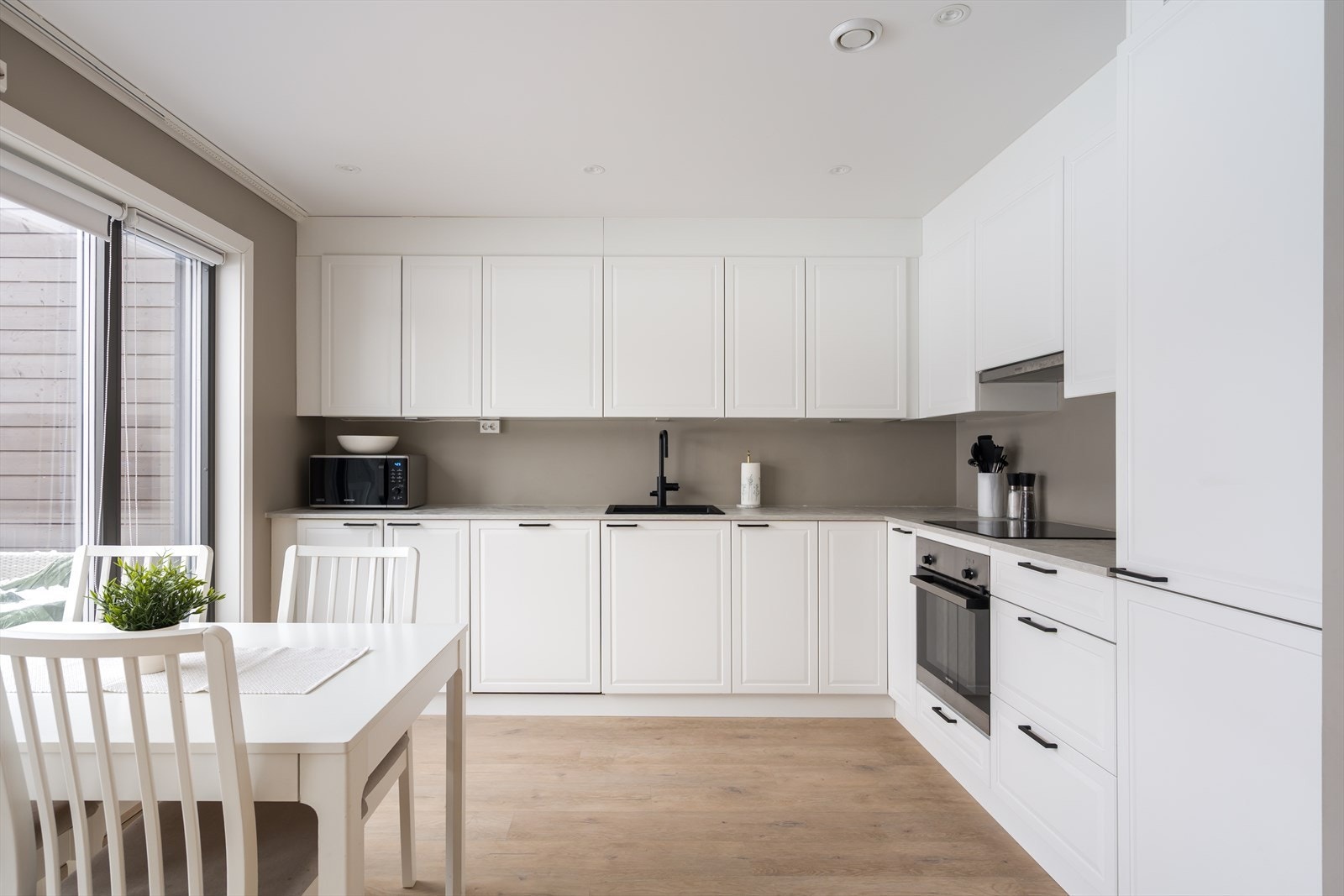 Kjøkkenet er oppført i en funksjonell L-form med god arbeidsflyt og skapplass. Galleribilde