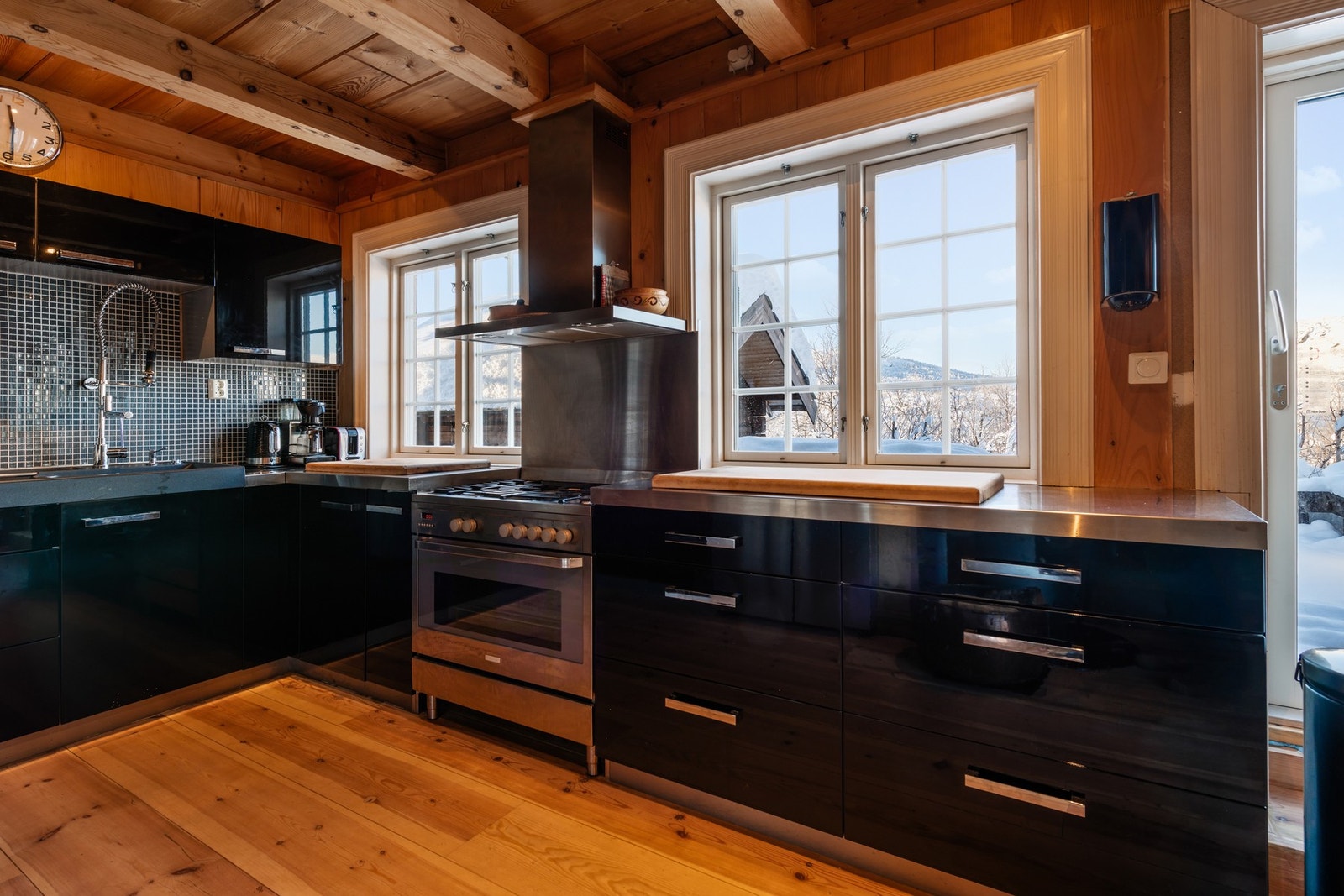 Glatte, moderne fronter og benkeplater av rustfritt stål gir en moderne kontrast til det ellers rustikke interiøret. Galleribilde