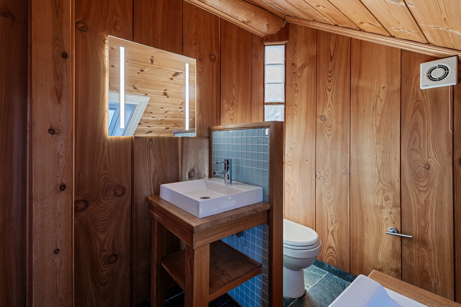 Skiferfliser på gulv, trepanel på vegg og i himling. Galleribilde