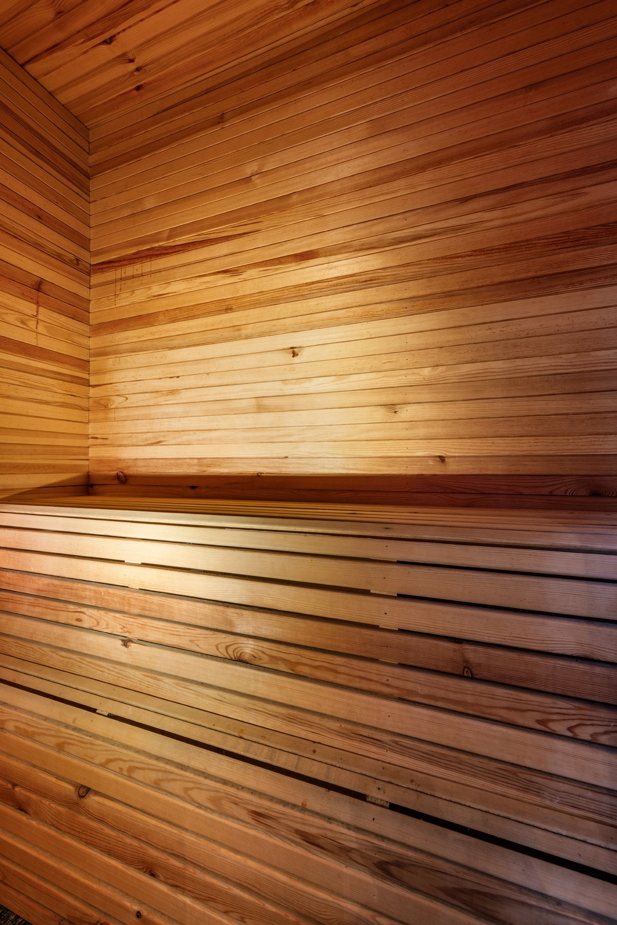 Badstue har skiferfliser på gulvet, og sittebenk i trematerialer. El. badstuovn. Galleribilde