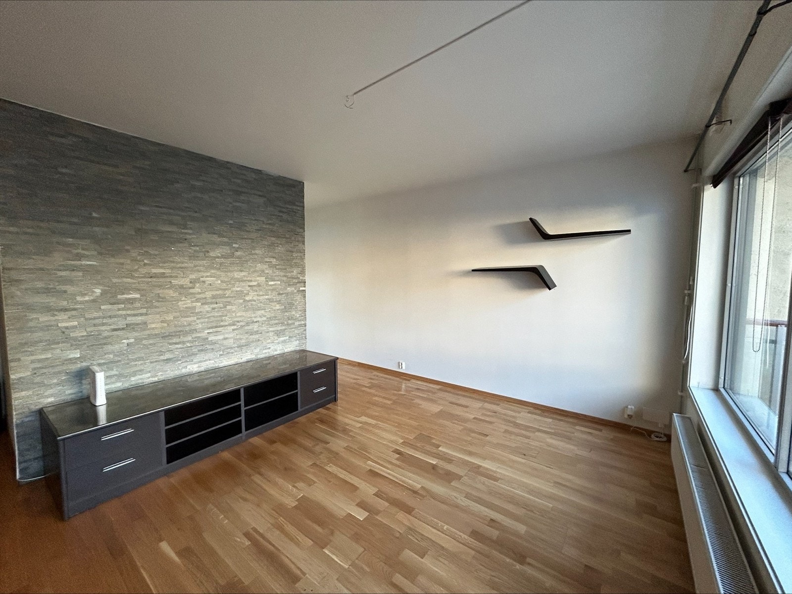 Romslig og åpen stue med store vindusflater og balkong Galleribilde