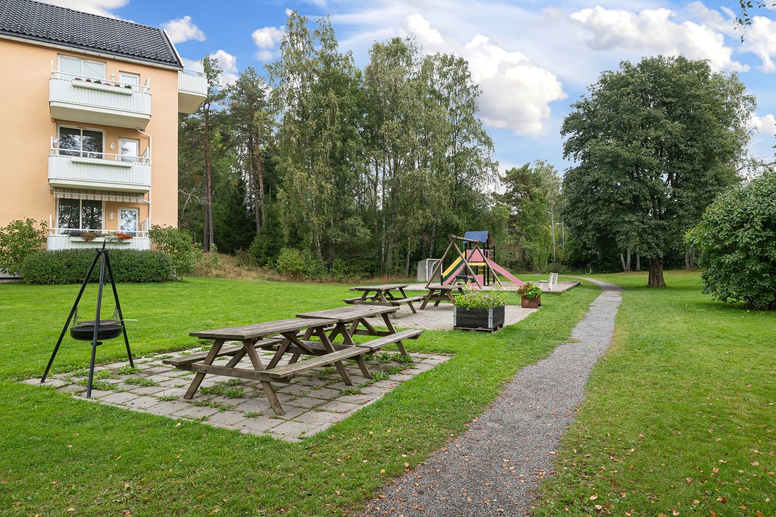 Felles uteområder med plen, benker og grillplass - frodig og trivelig om sommeren. Galleribilde