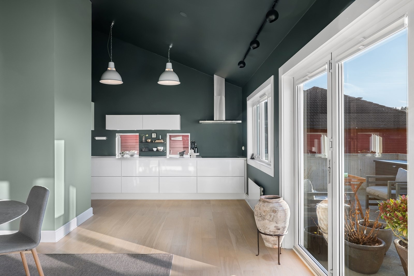 Et virkelig fantastisk familierom og samlingspunkt. Dette er hjerte i huset. Her har du masse plass til spisestue og lounge ved peisen og du glir sømløst ut på fine dager når foldedørene er åpnet. Galleribilde