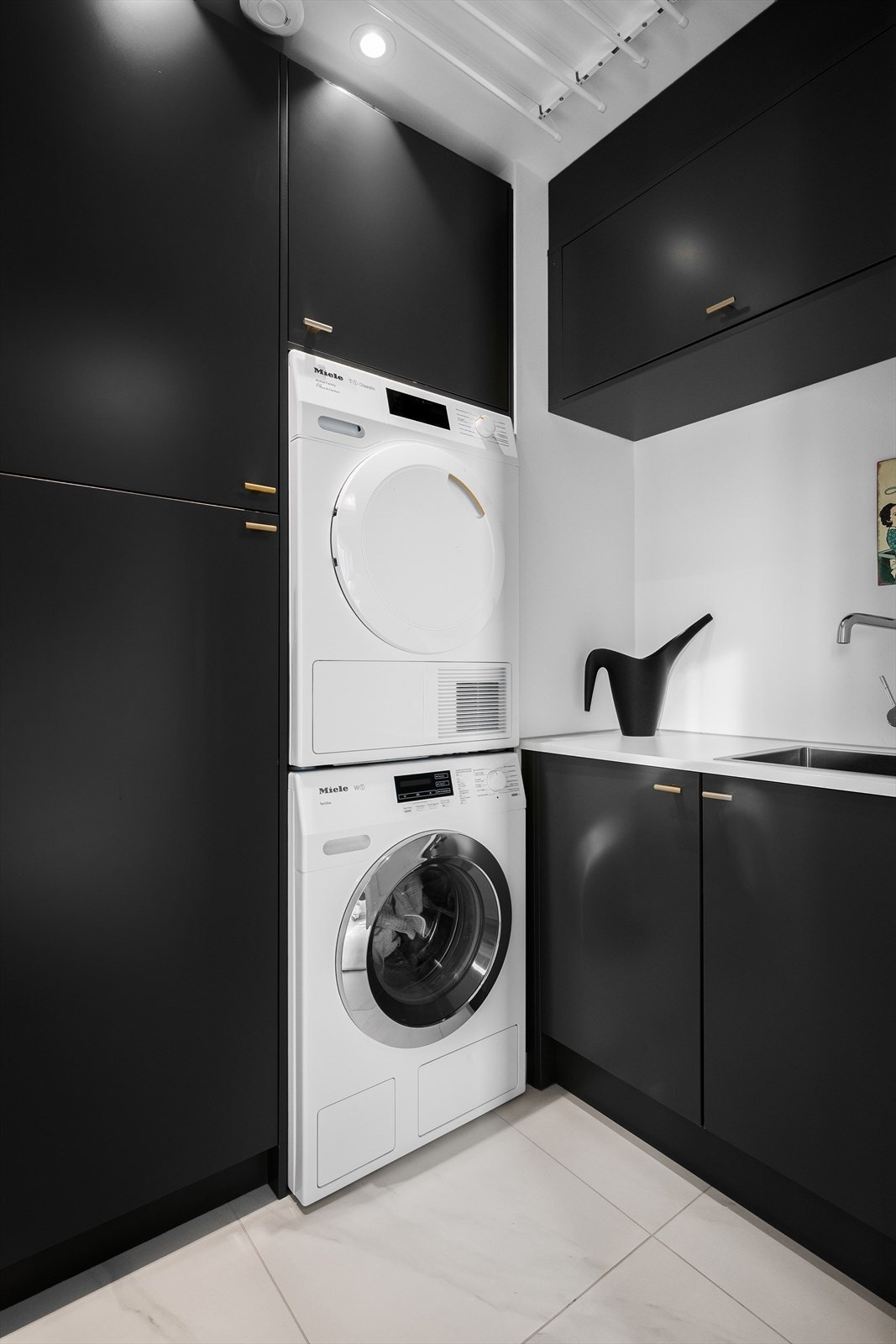 Eget, lite vaskerom med genialt utnyttet skapplass og opplegg for tørking av klær. Vaskerom, toalett og deler av kjeller har eget ventilasjonsanlegg. Galleribilde