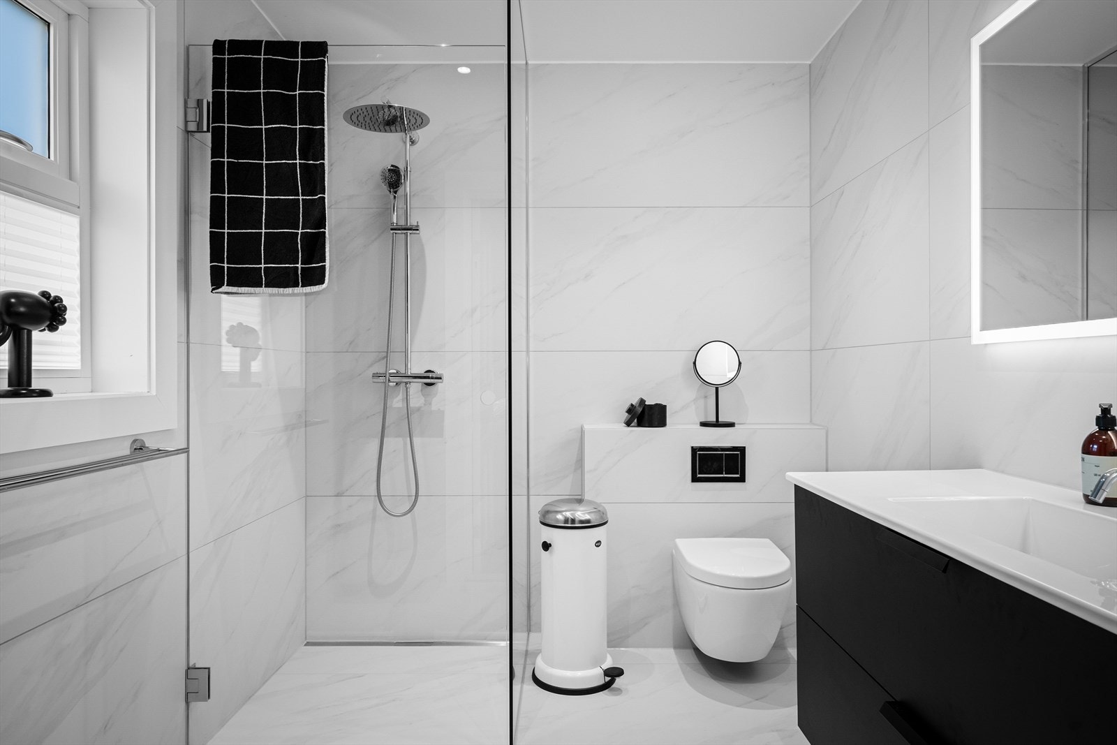 Delikat og moderne baderom med vannfallsdusj og håndholdt, stor seksjon og speil med lys. Vindu for naturlig lys. Håndkleholder. Galleribilde