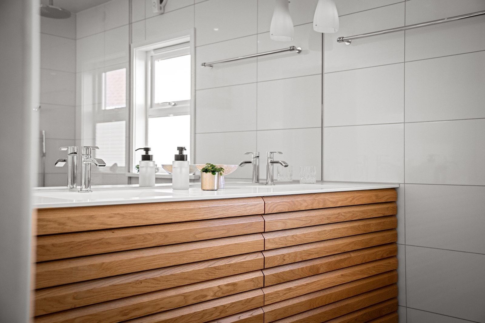 Dobbel servant i seksjon med lunt tre i kontrast til fliser. Enkelt med morgen- og kveldsstell. Galleribilde