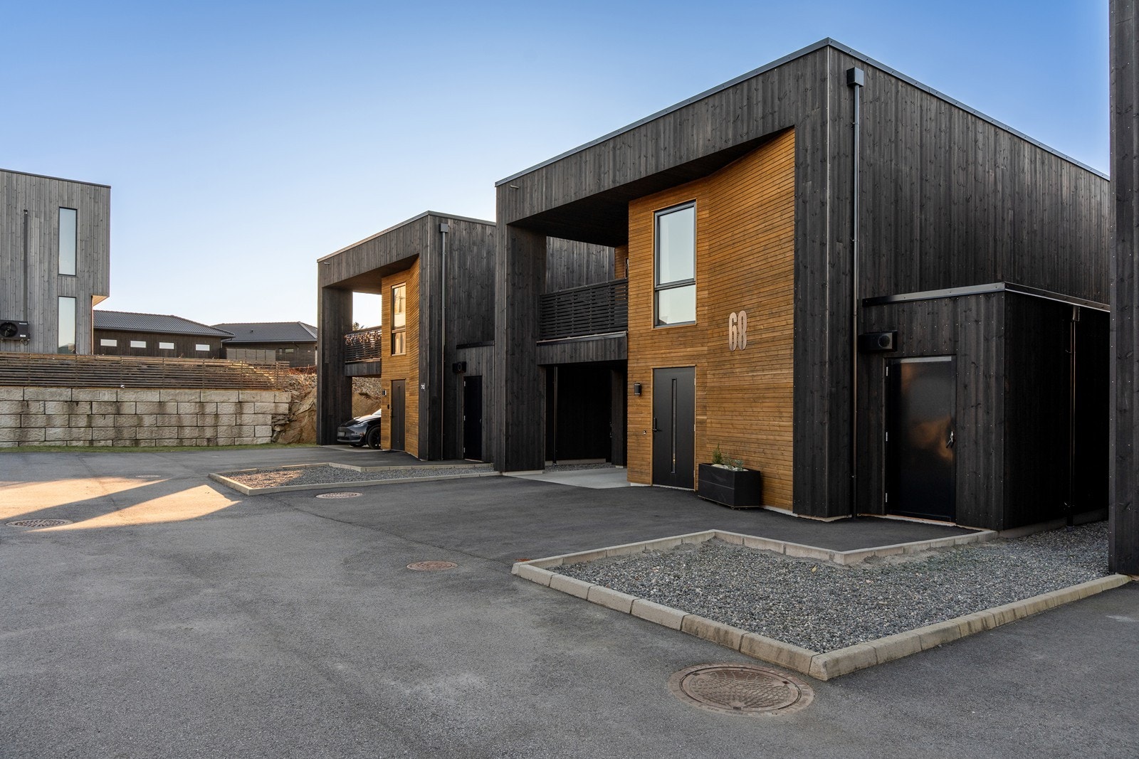 Asfaltert gardstun med parkering i carport m/el-bil lader. Utvendig bod. Galleribilde