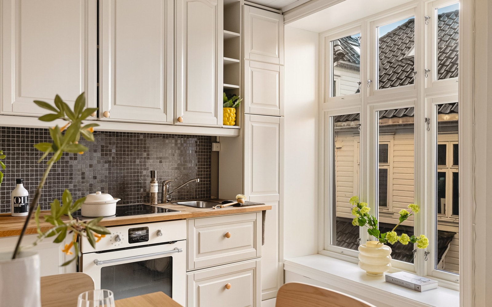 Kjøkkeninnredningen består av profilerte fronter, heltre benkeplate, over benkeplaten er det benyttet fliser og stål oppvaskkum. Galleribilde