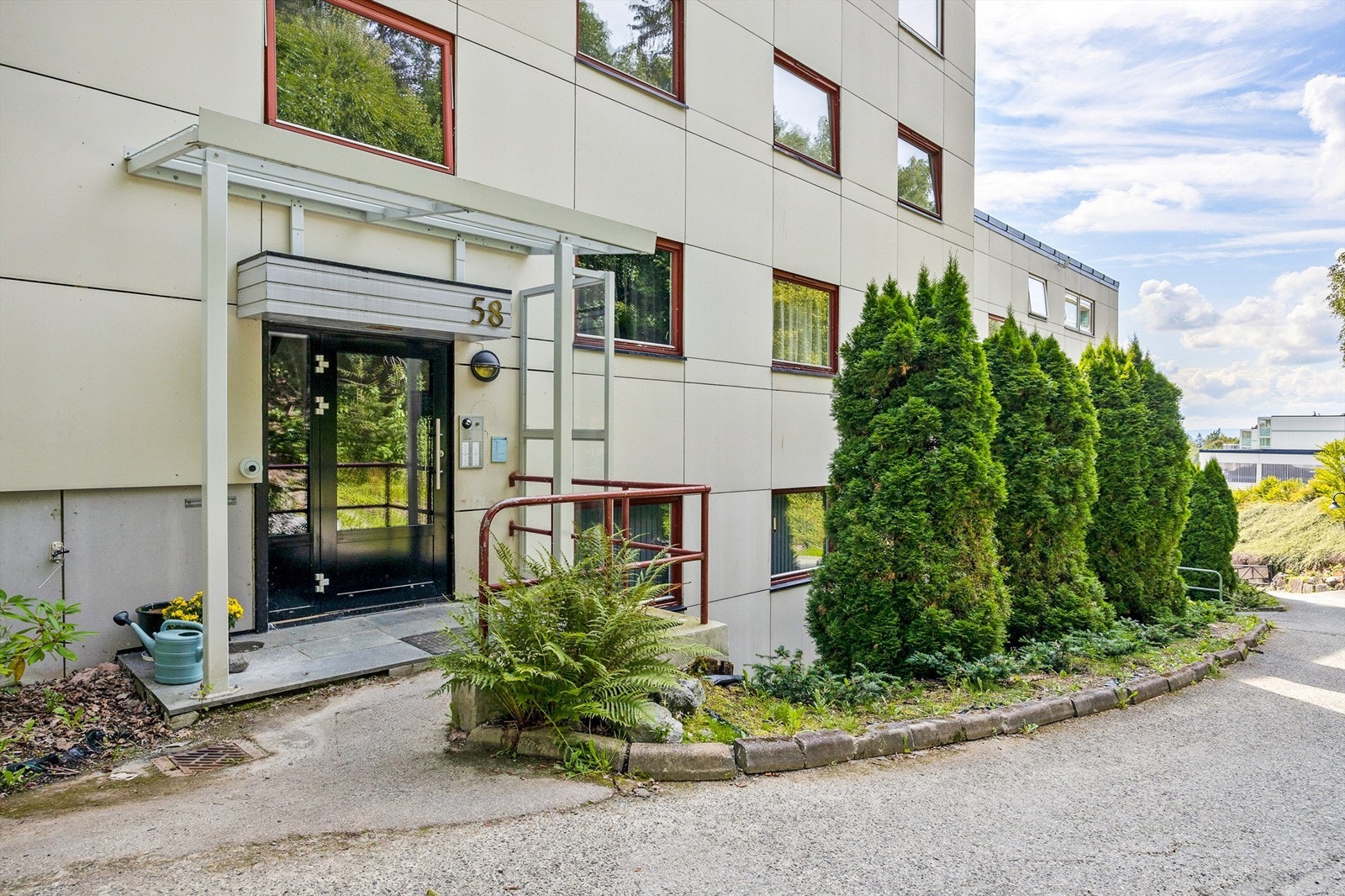 Felles overbygget inngangsparti med videre trappeadkomst ned til leilighetens etasjeplan Galleribilde