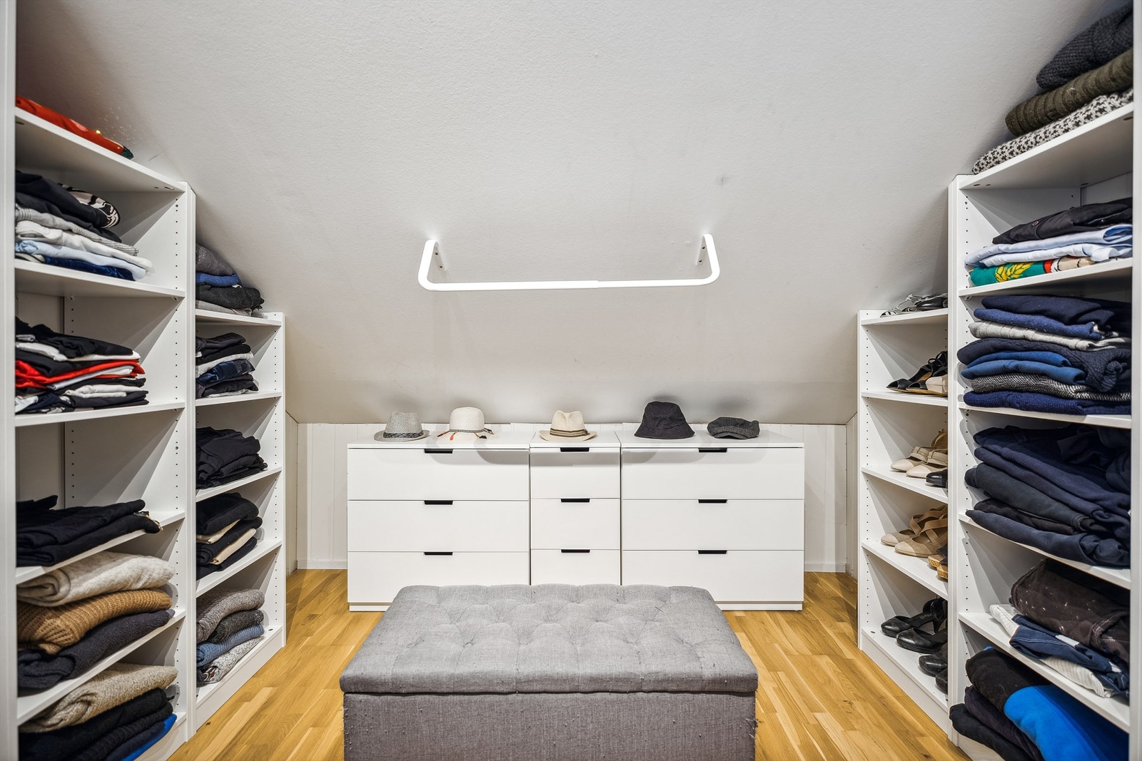 Romslig omkledningsrom med praktisk garderobeløsning Galleribilde