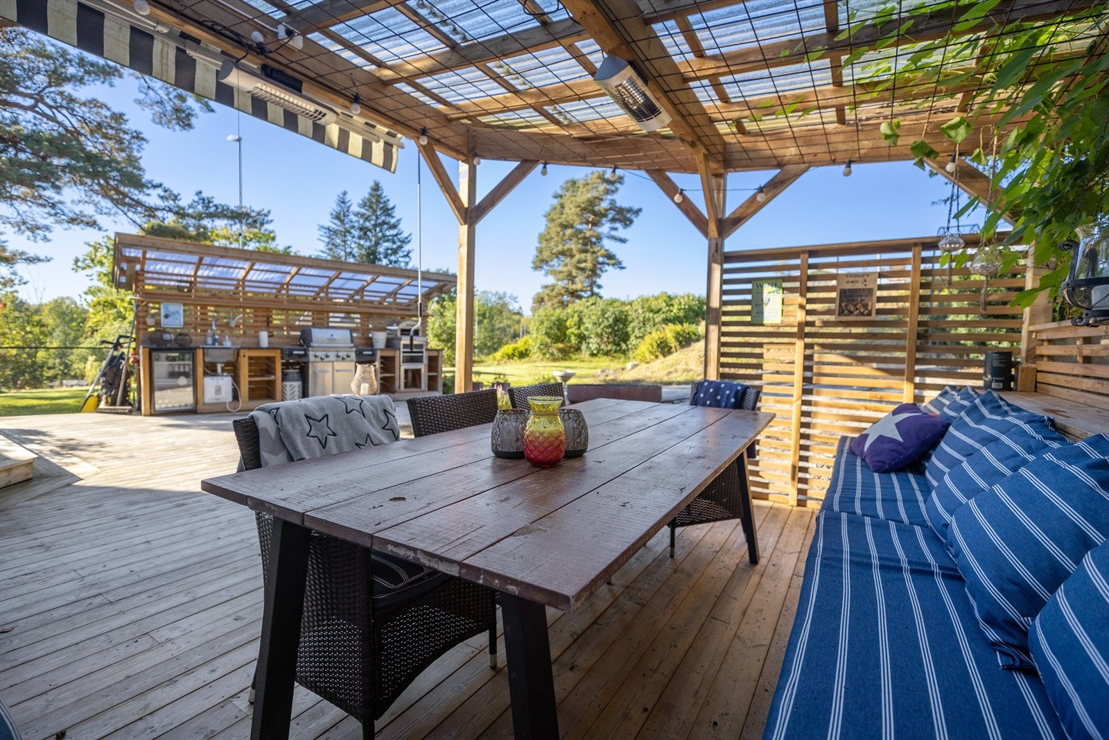 På nordsiden av boligen finner du et flott uteområde som er pent opparbeidet med pergola, fullt utstyrt kjøkken samt en hyggelig bålplass Galleribilde