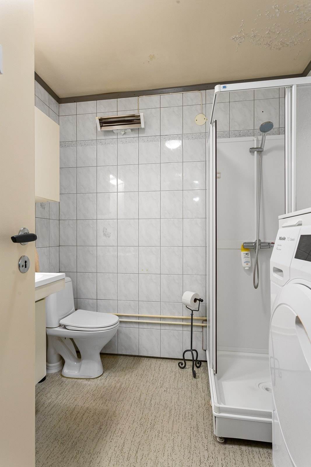 Badet har belegg på gulv, fliser på vegger og malt himling Galleribilde