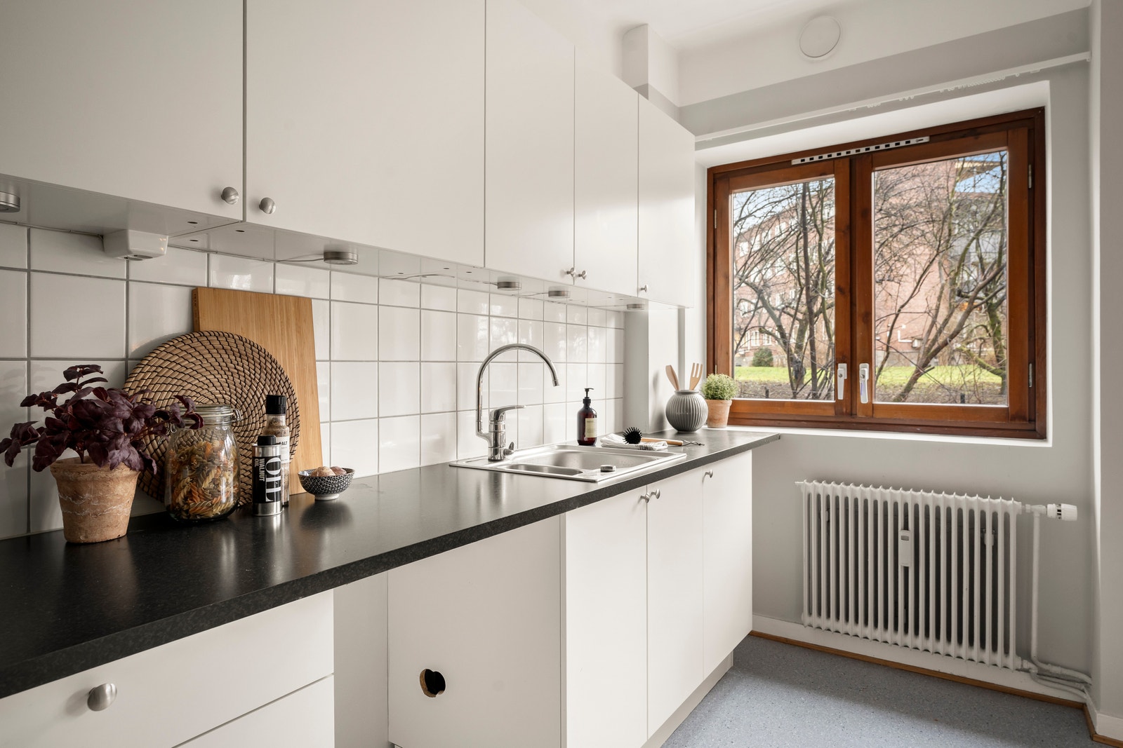 Kjøkken fra HTH i lyse, moderne farger, med opplegg for oppvaskmaskin, benkbelysning og plass til spisegruppe. Galleribilde