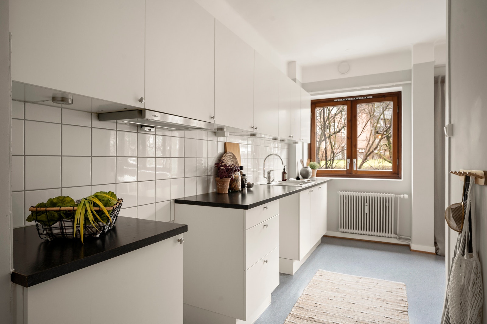 Kjøkken fra HTH i lyse, moderne farger, med opplegg for oppvaskmaskin, benkbelysning og plass til spisegruppe. Galleribilde