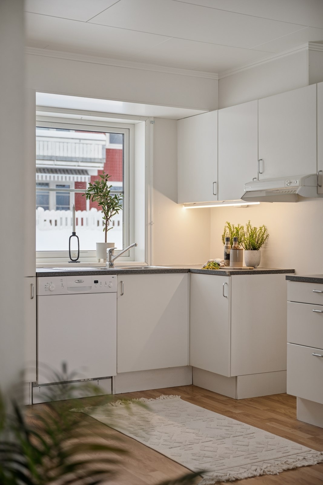 Lys og tidløs innredning med hvite slette fronter og benkeplate av typen laminat. Galleribilde