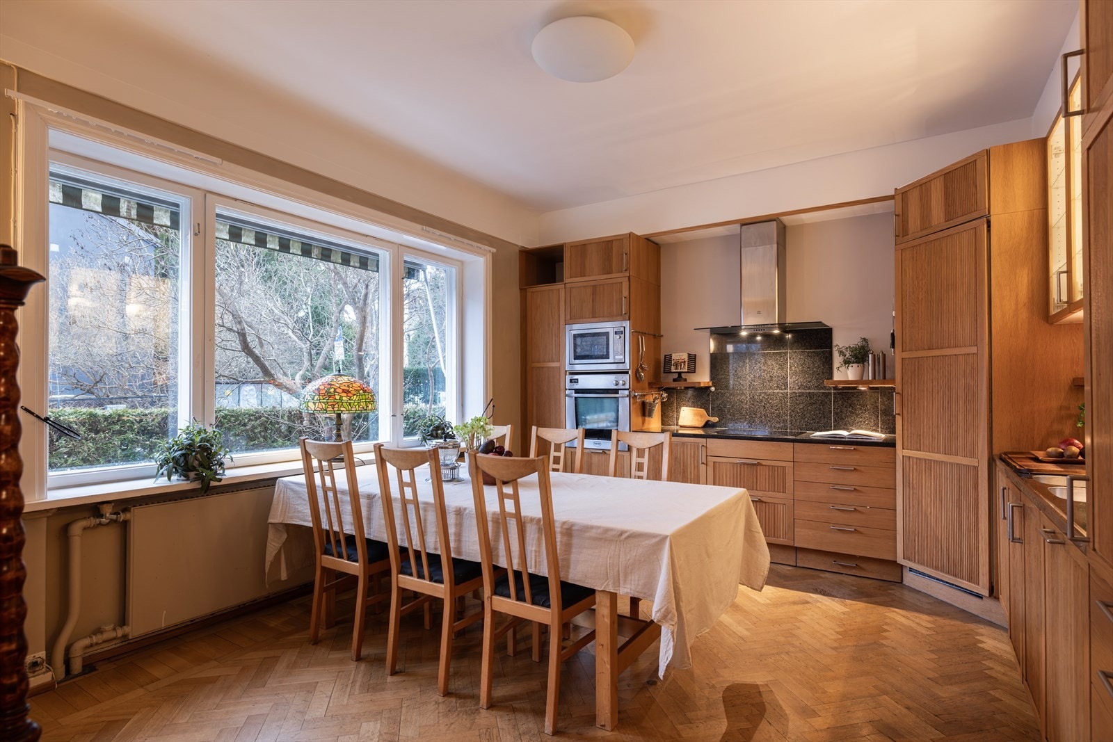 Stort spisekjøkken med profilerte fronter samt overskap med glassfronter og innvendig belysning. Galleribilde