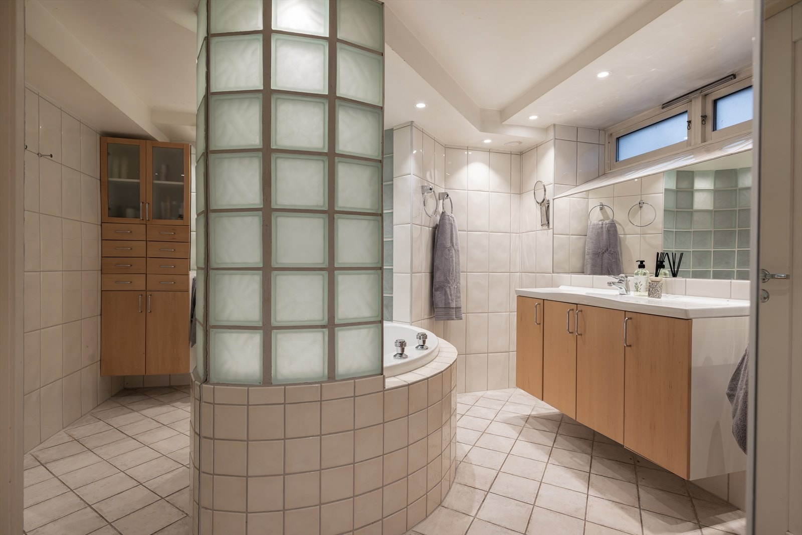 Rommet har innredning med nedfelt servant, toalettrom, stort innmurt hjørnebadekar og dusjvegger/hjørne. Galleribilde