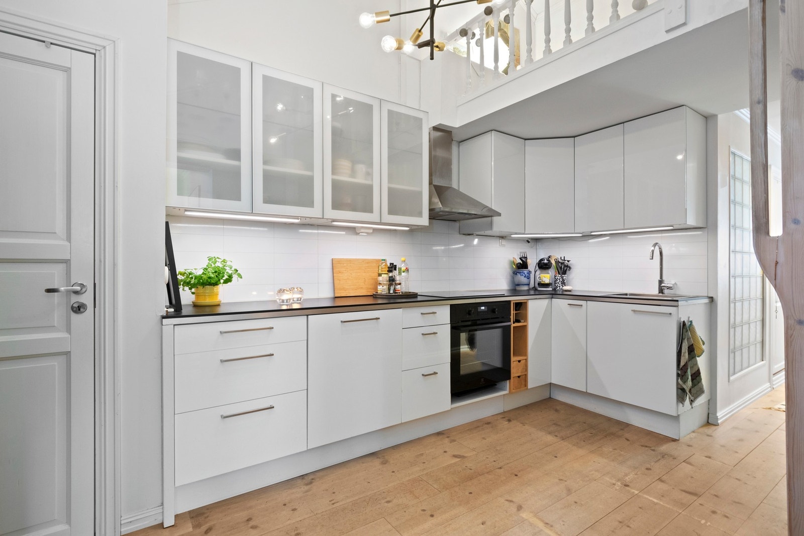 Et lyst og innbydende kjøkken fra 2007 med overskap og komfyr fra 2026. Galleribilde