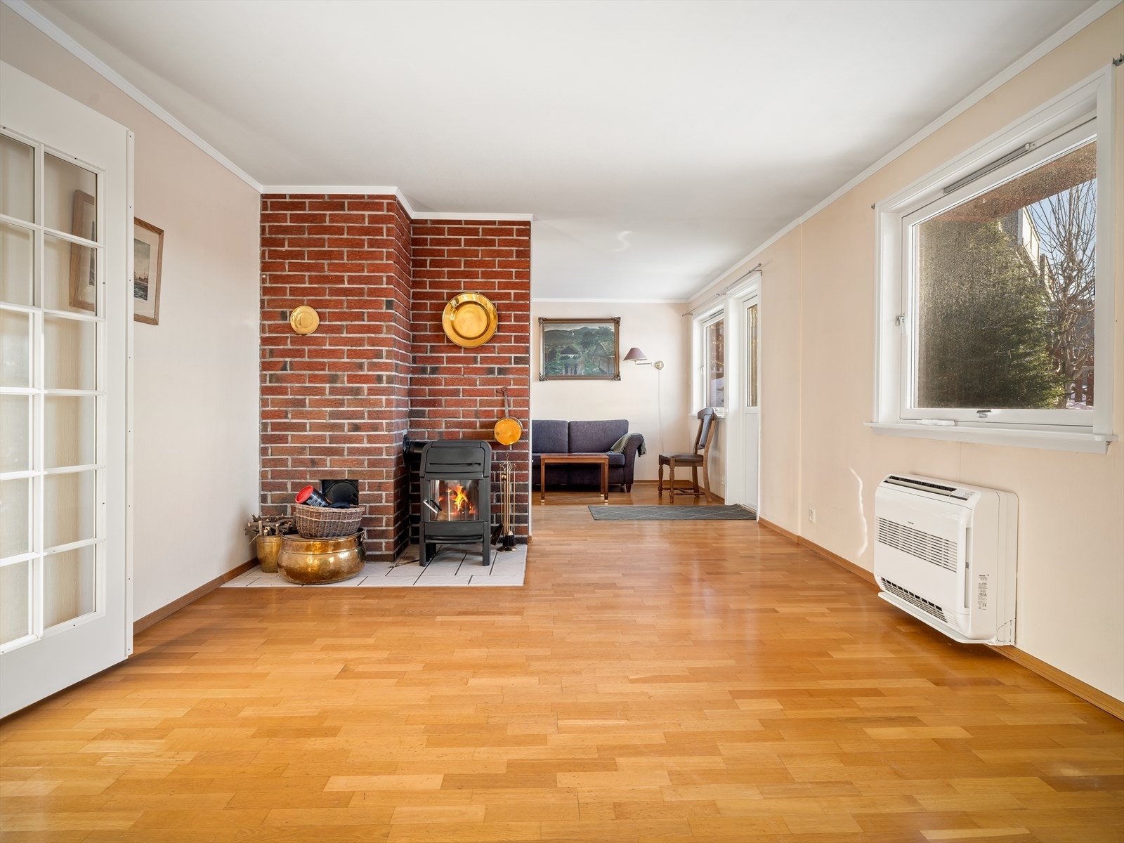 En murt peis med vedovn skaper en lun atmosfære i stuen. Galleribilde