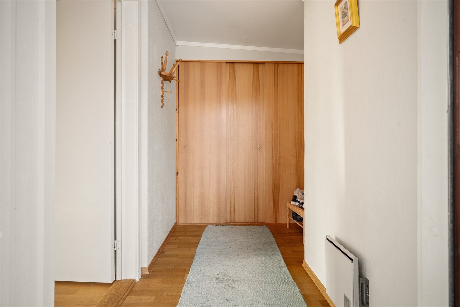 Praktisk entré med god plass til oppbevaring av yttertøy i skyvedørsgarderobe. Galleribilde