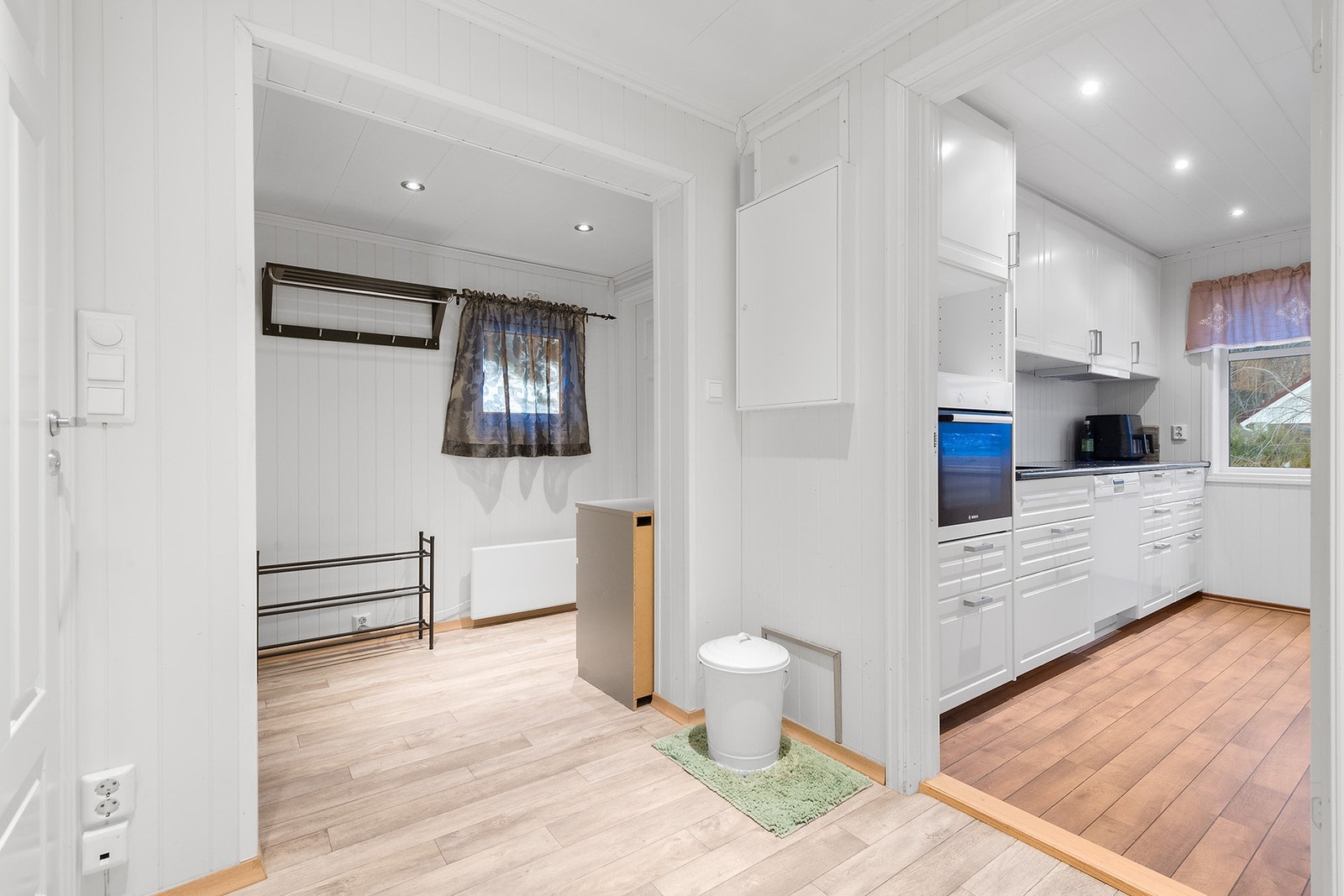 Tilkomst fra gang til kjøkken. Lyse overflater med downlights. Galleribilde