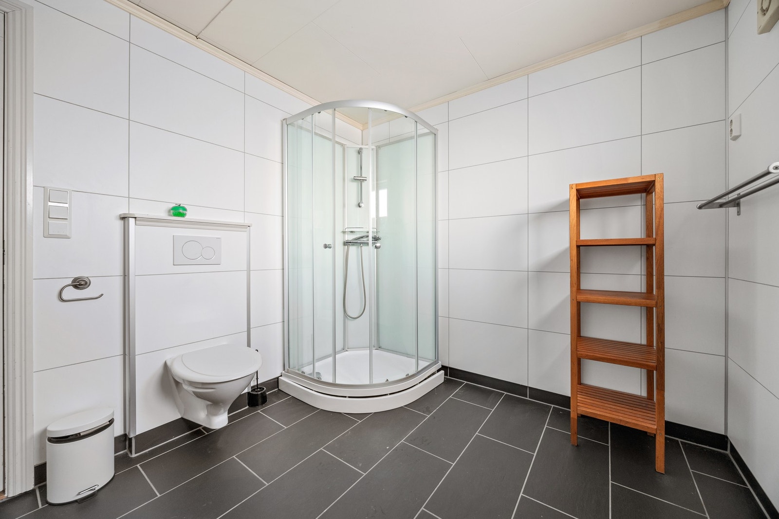 Badet er utstyrt med dusjkabinett, toalett og servantskap Galleribilde